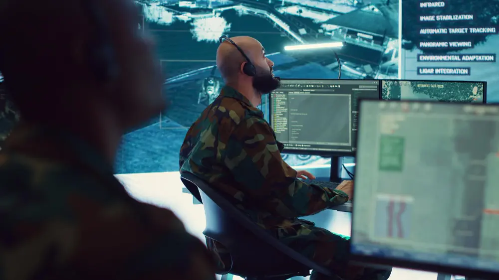 Analyst monitoring security dashboards in an operations center for a defense contractor