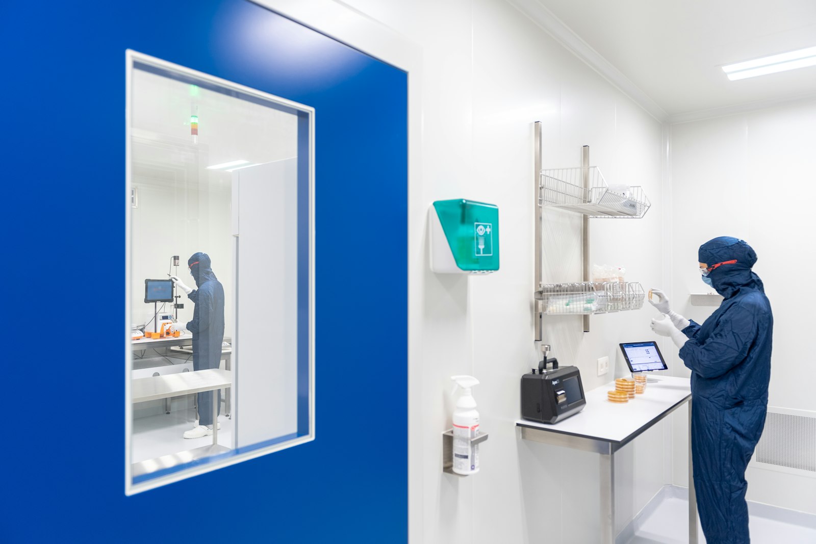 Technician working on a laptop inside a pharmaceutical cleanroom
